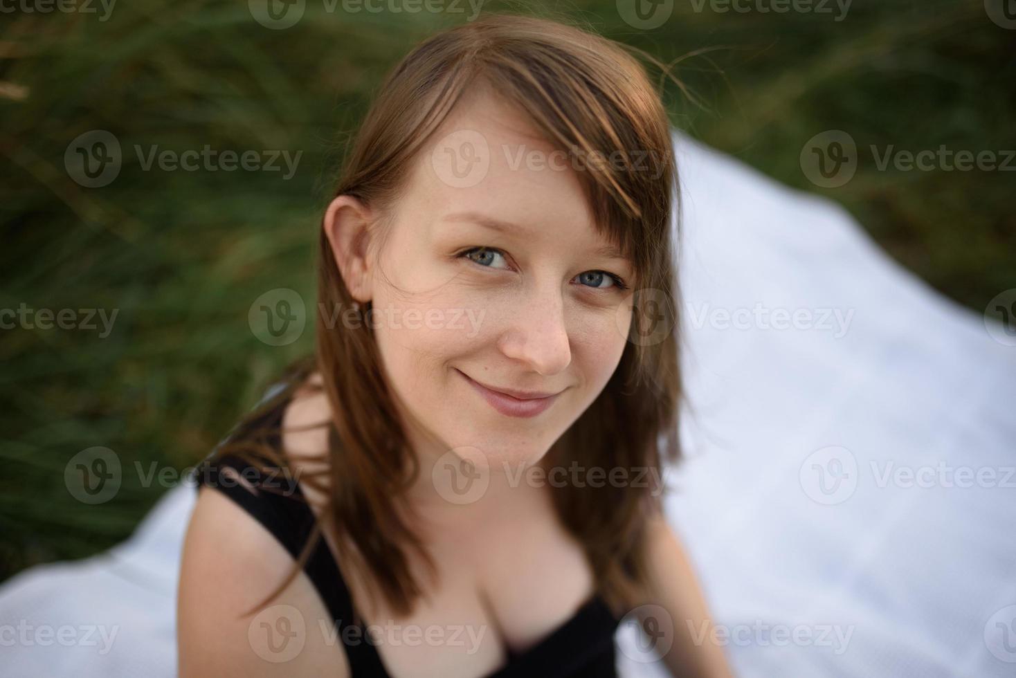 mulher bonita desfrutando de campo de margaridas, bela fêmea deitada no prado de flores, menina bonita relaxante ao ar livre, se divertindo, segurando a planta, jovem feliz e natureza verde primavera, conceito de harmonia foto