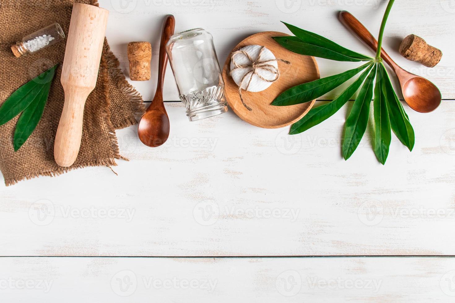 conceito de desperdício zero. utensílios de cozinha recicláveis naturais em um fundo branco de madeira. foto