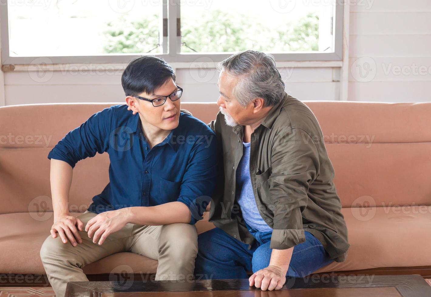 pai asiático sênior dá conselhos filho adulto na sala de estar, homem idoso dando conselhos a seu filho adulto, conceitos de família de felicidade foto