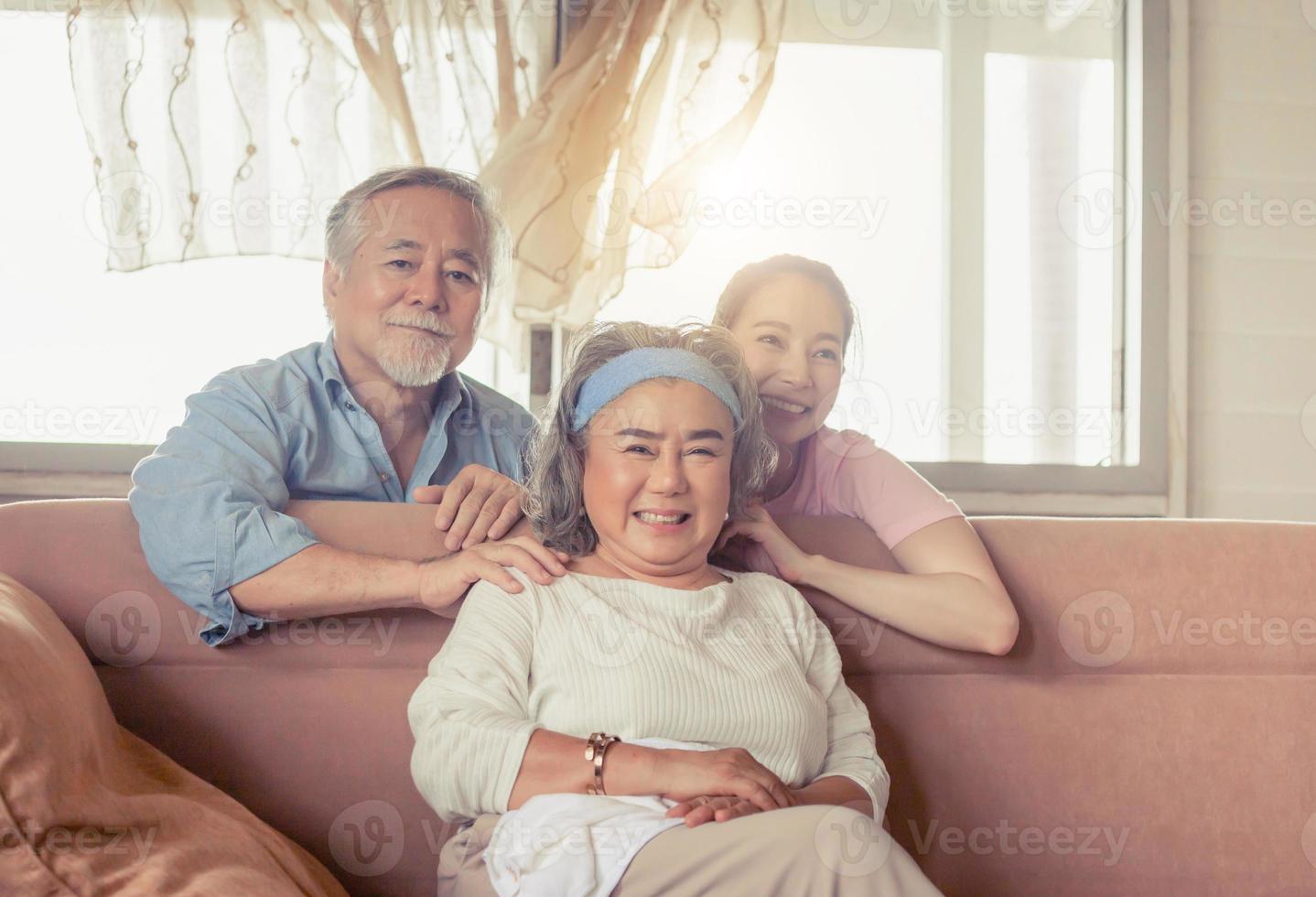 família asiática sentada na sala de estar, pai sênior mãe e filha de meia idade, conceitos de família de felicidade foto