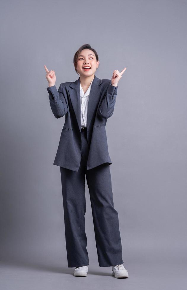 jovem mulher de negócios asiáticos em fundo cinza foto