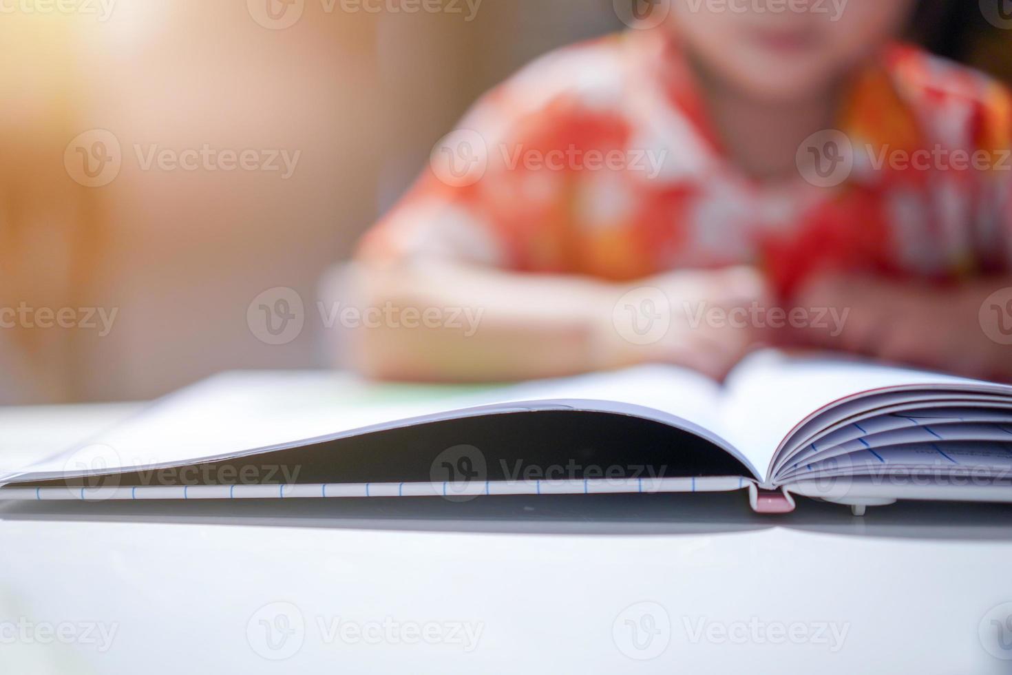 garota asiática concentrada leu um livro, feche o livro. com luz de clarão. foto