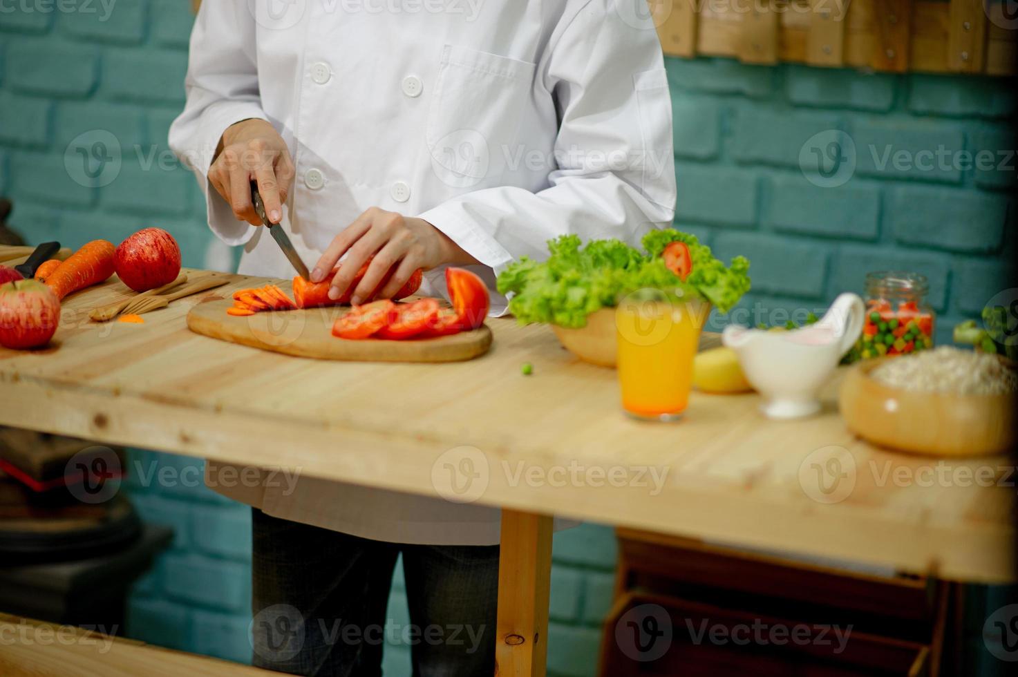 mão do chef, cozinhar salada de legumes, conceito de culinária saudável foto