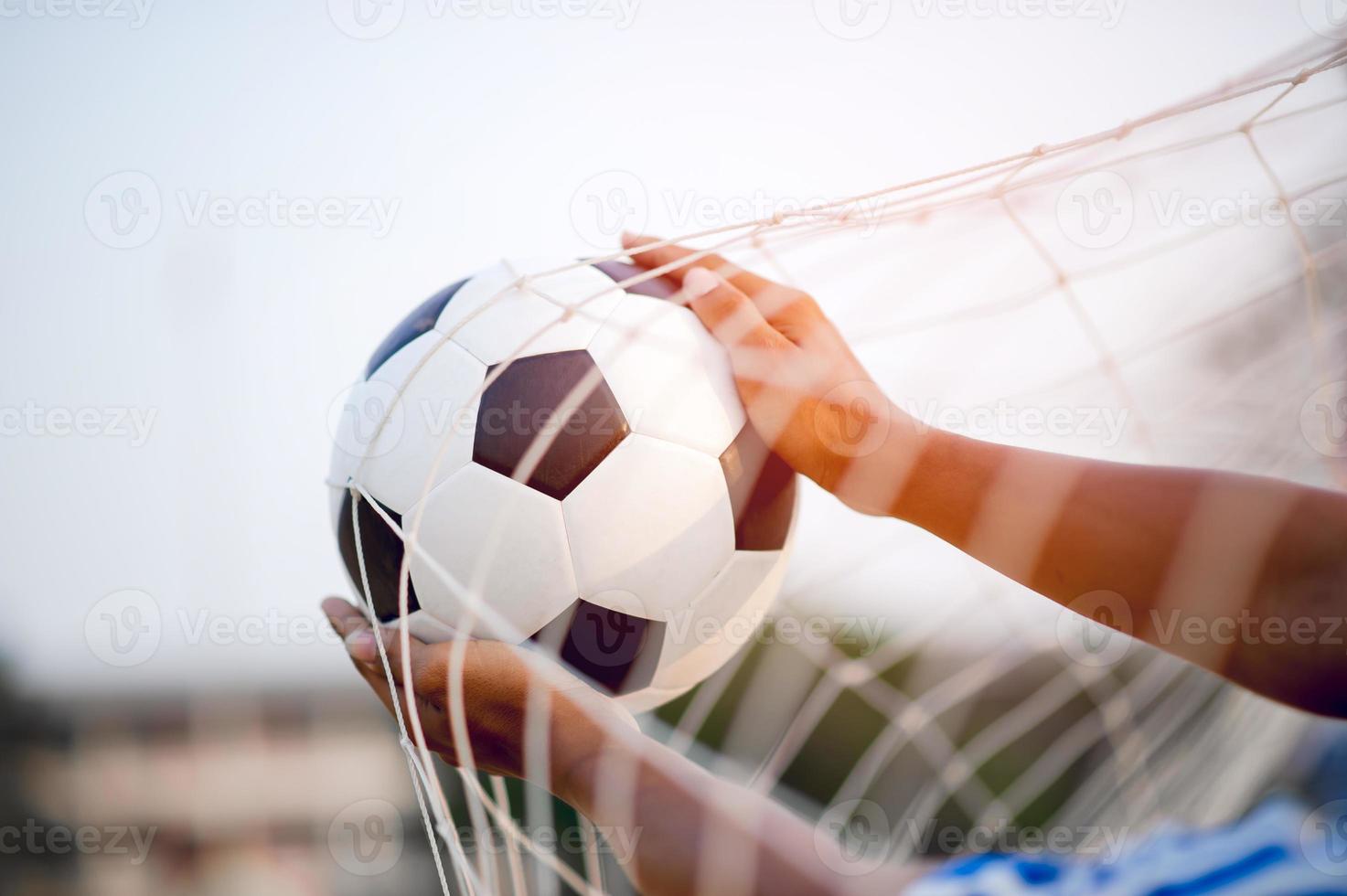 a imagem recortada de jogadores de esportes que pegam a bola e o campo de futebol. conceito de imagem esportiva. foto