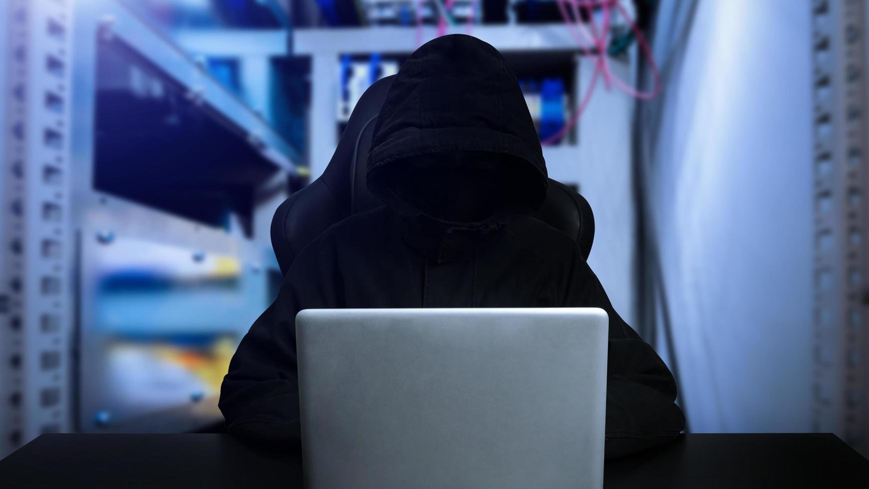 hacker usando computador com interface digital enquanto está sentado na mesa do interior embaçado. conceito de hacking e ladrão. foto
