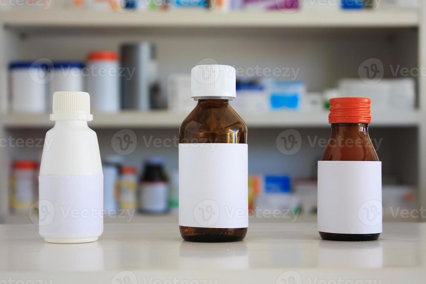 rótulo branco em branco do frasco de remédio com prateleiras desfocadas de drogas no fundo da farmácia foto