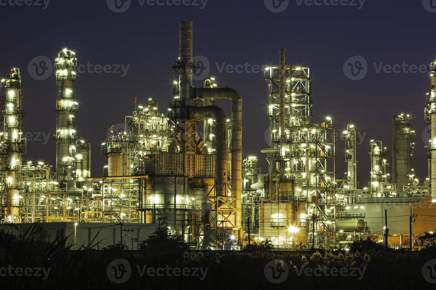 cena crepuscular da planta de refinaria de petróleo do tanque e coluna de torre de petroquímica foto