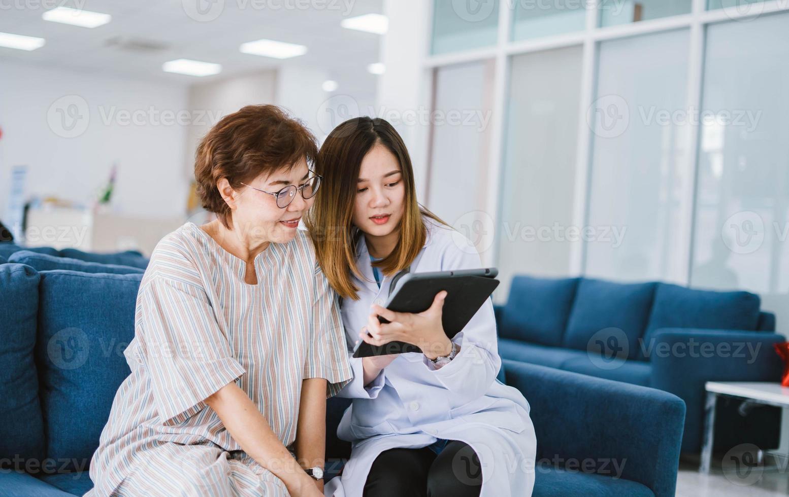 jovem médico consultando paciente sênior na clínica de saúde foto