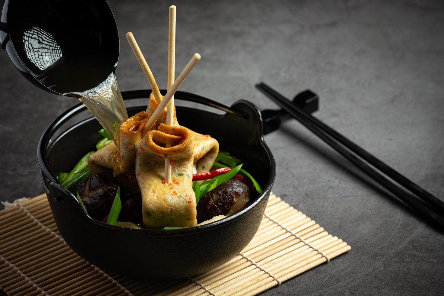 bolo de peixe coreano e sopa de legumes na mesa foto
