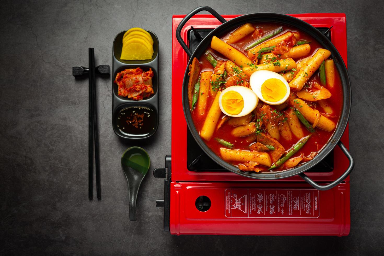 comida tradicional coreana de queijo tokbokki no fundo da placa preta. prato de almoço. foto