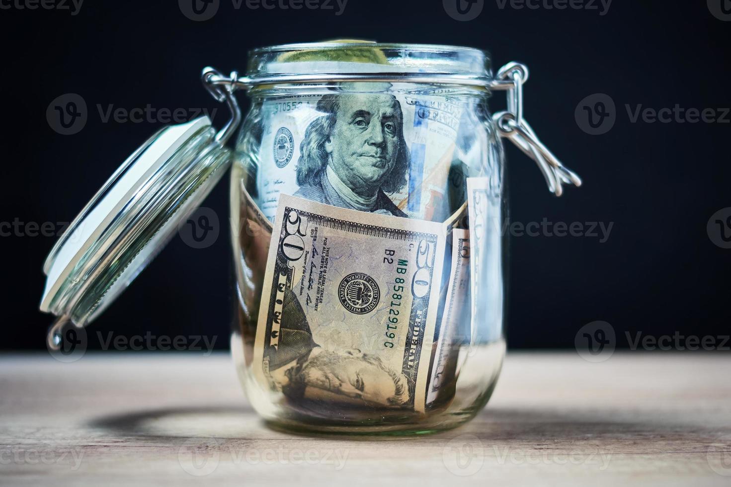 notas de dólar de papel em frasco de vidro, conceito de economia de dinheiro foto