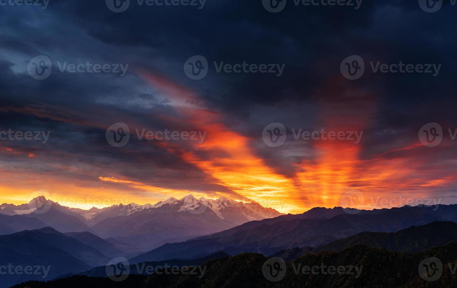 pôr do sol sobre os picos das montanhas cobertas de neve. foto