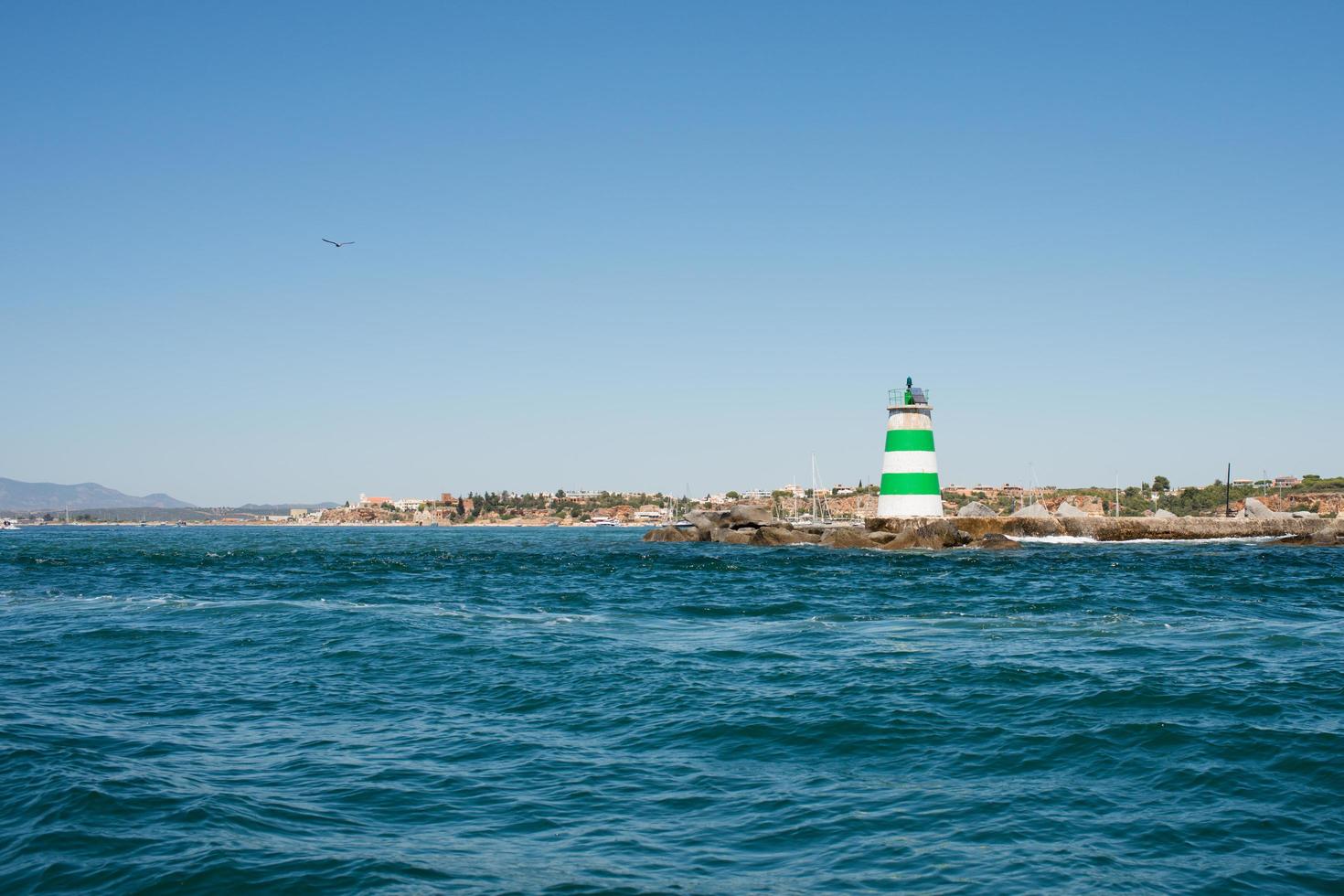 bela costa atlântica perto de portimão, algarve. farol com listras verdes e brancas. Portugal foto