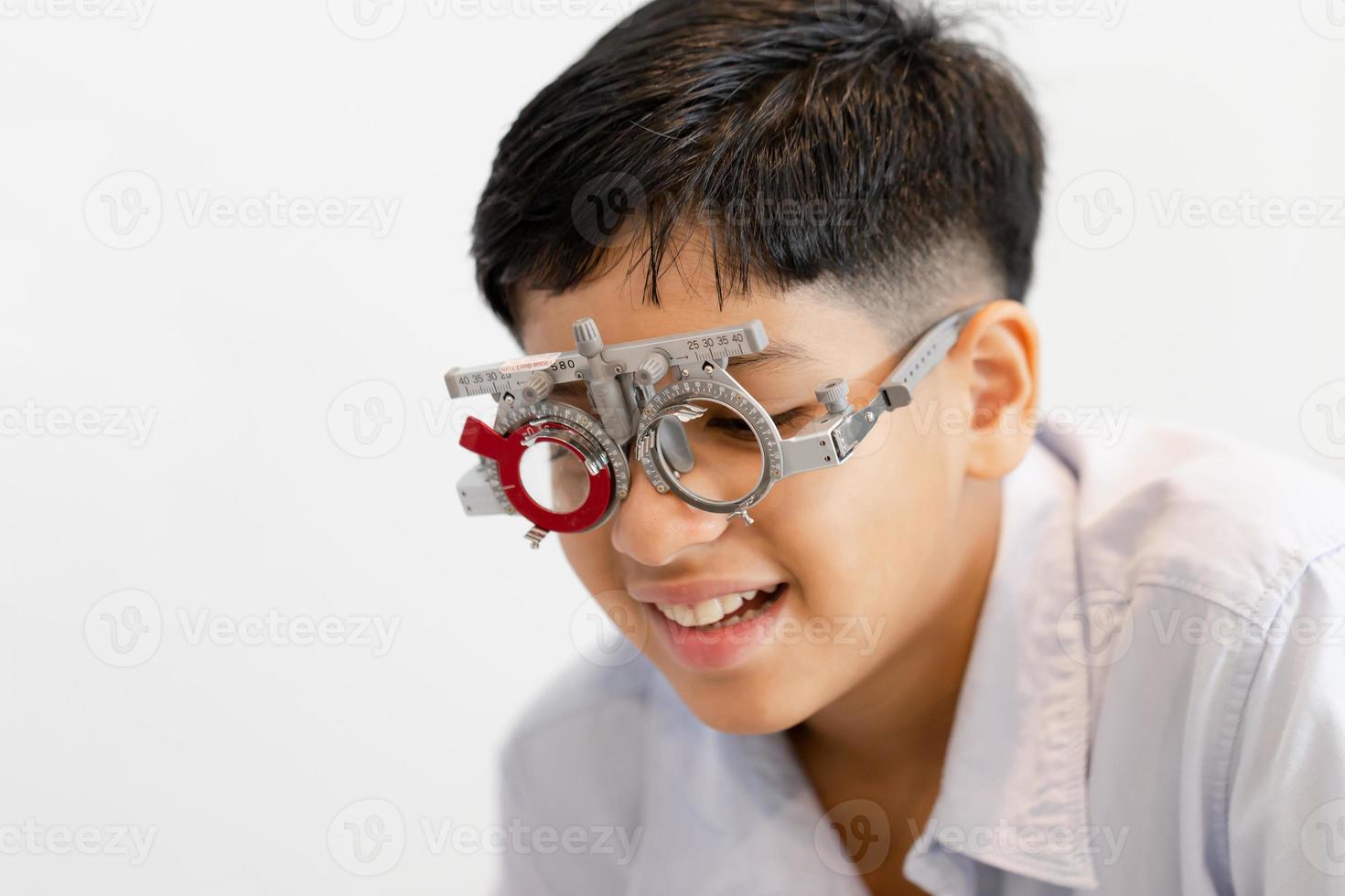 retrato de criança usando óculos de teste de olho na loja de óptica, sorrindo menino indiano escolhendo óculos na loja de óptica foto