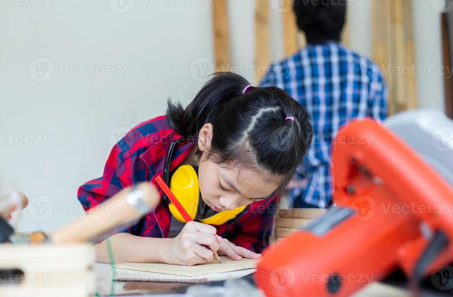 crianças aprendendo marcenaria na oficina de artesão, menino adolescente com sua irmãzinha construindo uma oficina juntos em uma oficina de carpintaria. foto