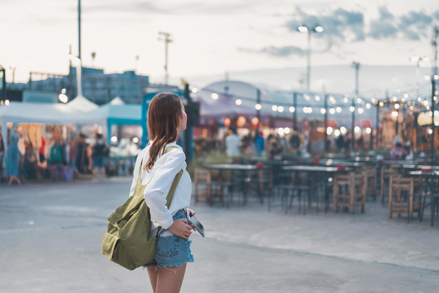 viajar mulher asiática andando no mercado noturno. foto