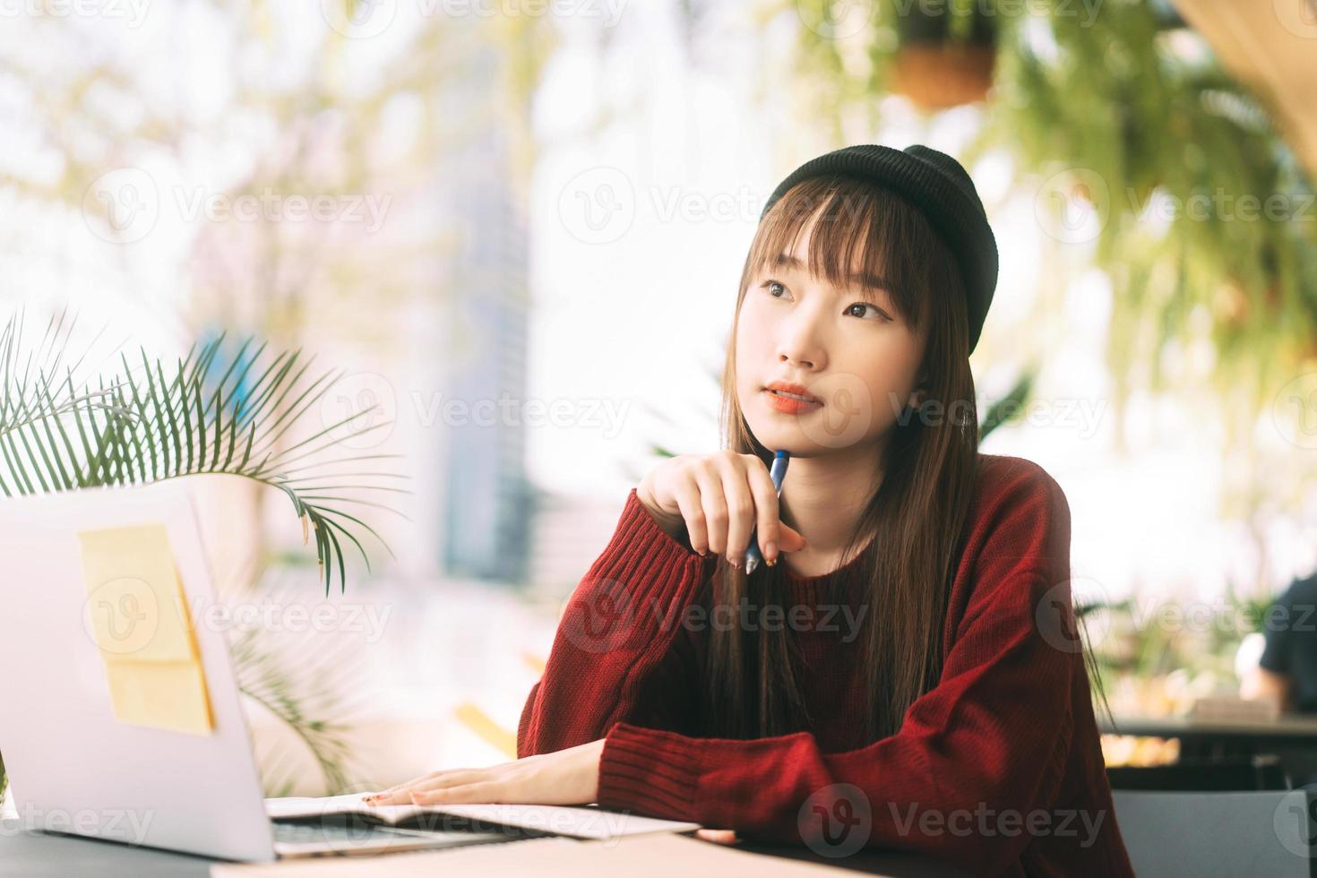 mulher estudante universitário adolescente asiático usando laptop para trabalhar e estudar no café no dia. foto
