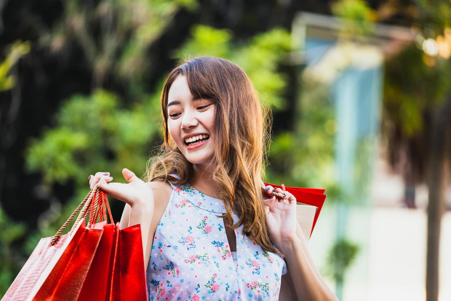 jovem mulher asiática segura bolsa vermelha no shopping. foto
