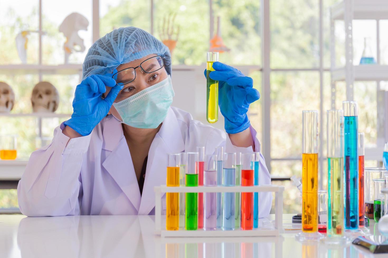 uma cientista asiática está pesquisando uma fórmula química em um laboratório. foto