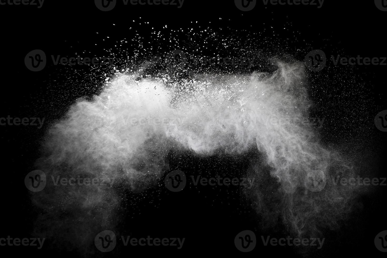 congele o movimento de respingos de partículas de poeira branca em fundo preto. foto