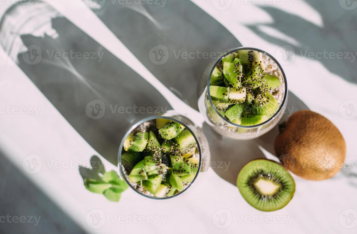 café da manhã saudável. pudim de chia com kiwi e granola em vidro foto