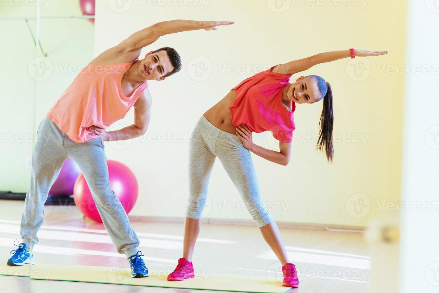 dois jovens na academia fazendo exercícios para fitness foto