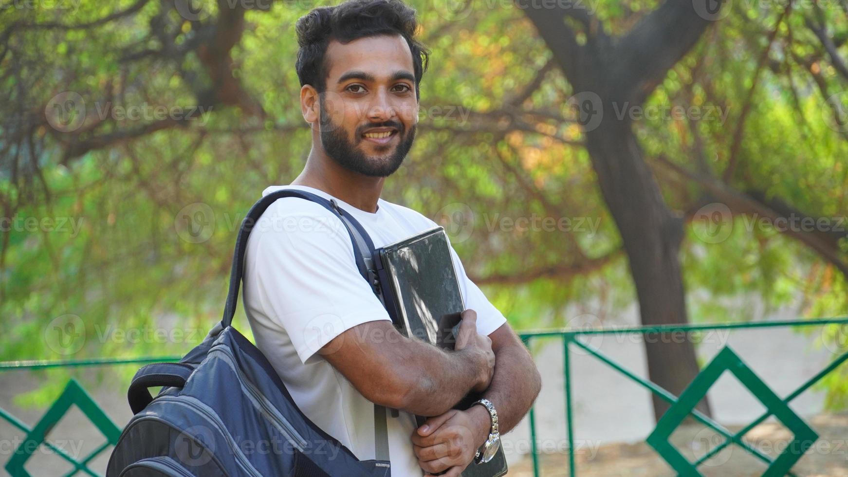 estudante moderno com laptop laptop perto do campus universitário foto