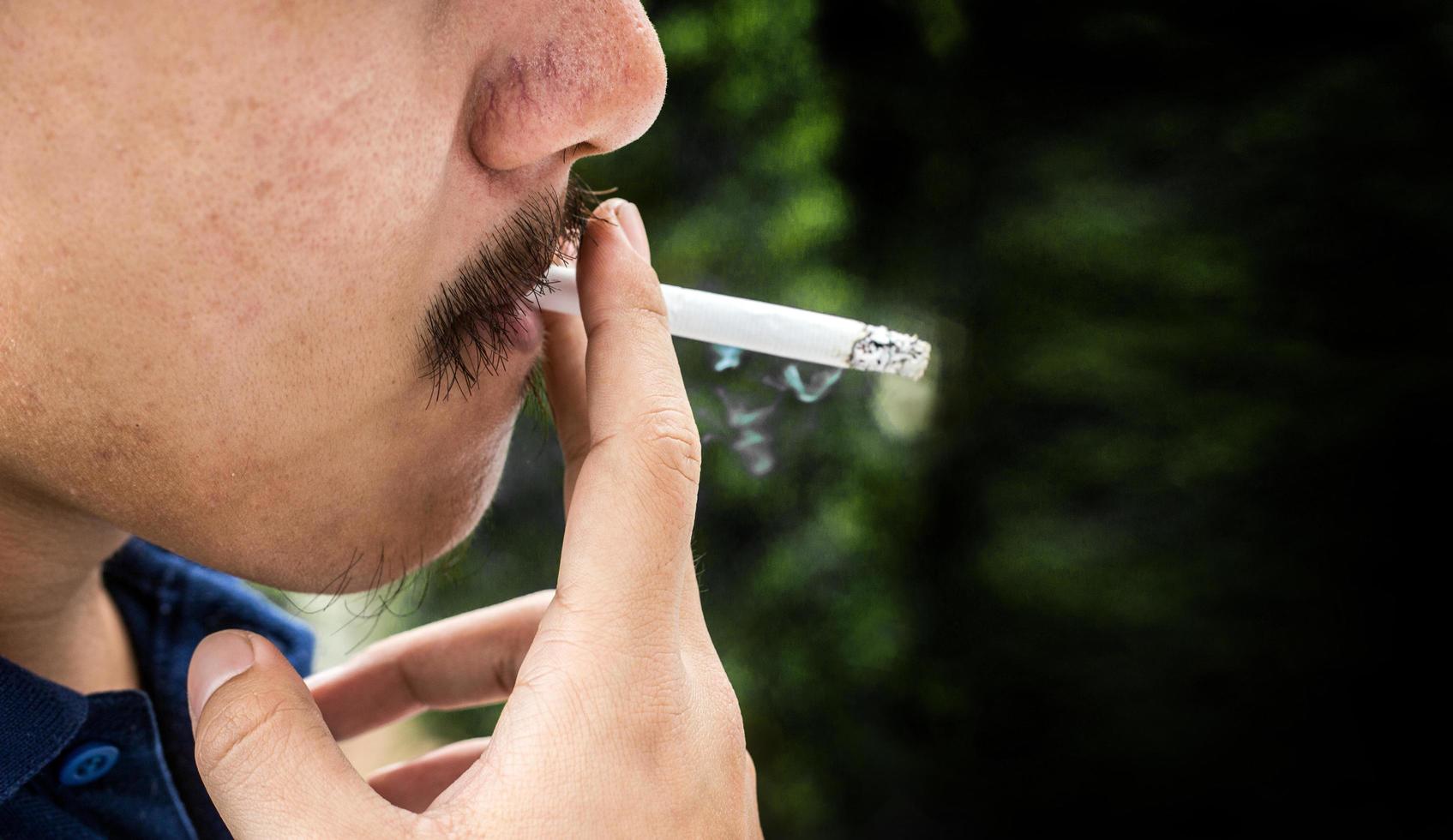 homem dedo asiático manter cigarro foto