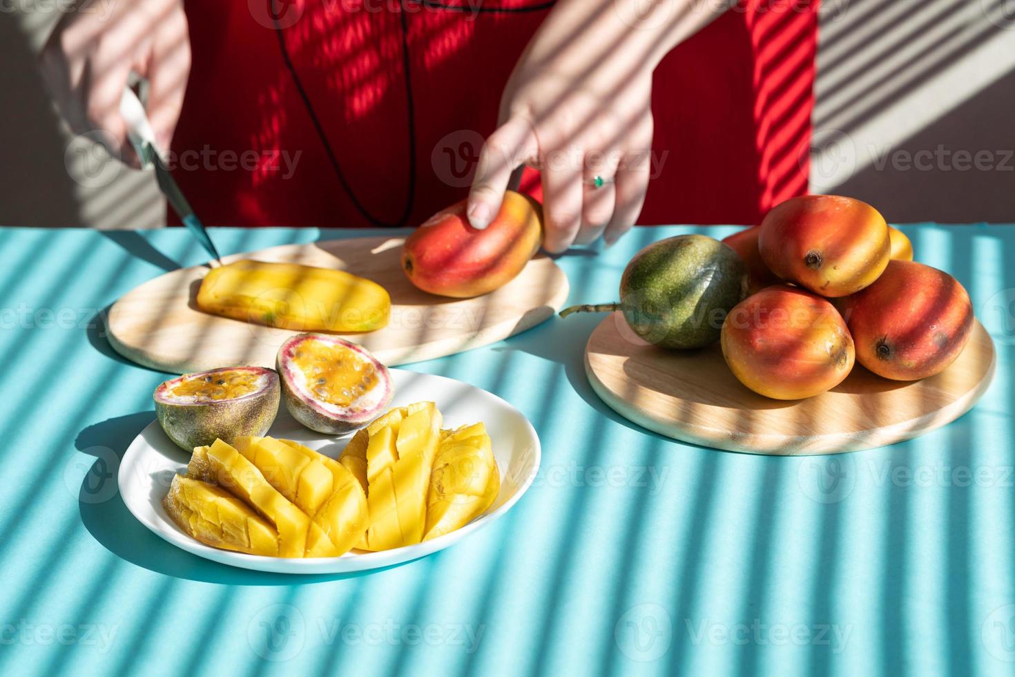 mãos femininas cortam manga e maracujá, café da manhã de frutas foto