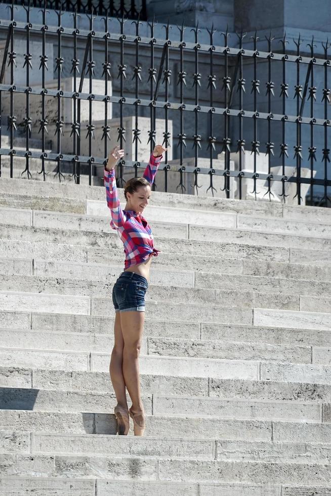 budapeste, hungria, 2014. bailarina posando nos degraus do prédio do parlamento húngaro foto