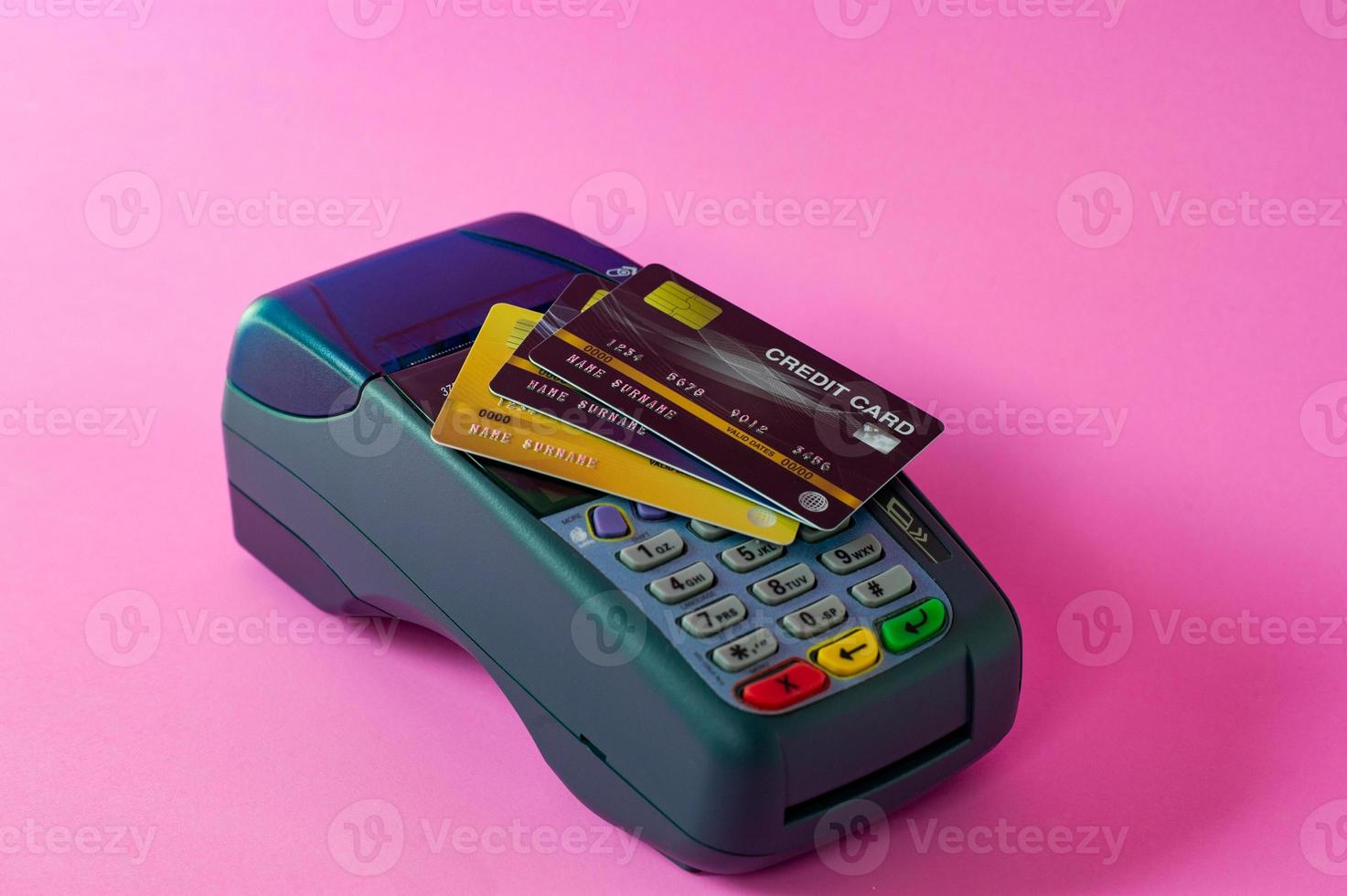 cartão de crédito e scanner de cartão de crédito em um fundo rosa foto