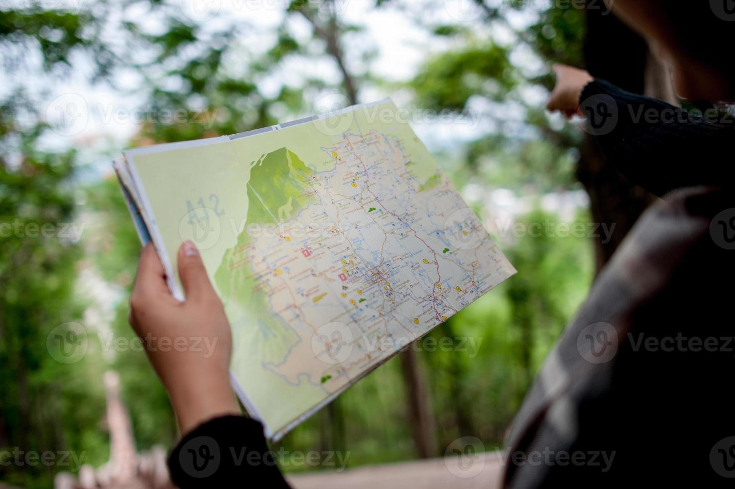 jovens turistas e um mapa com um sorriso ficam felizes em viajar para vários locais. foto