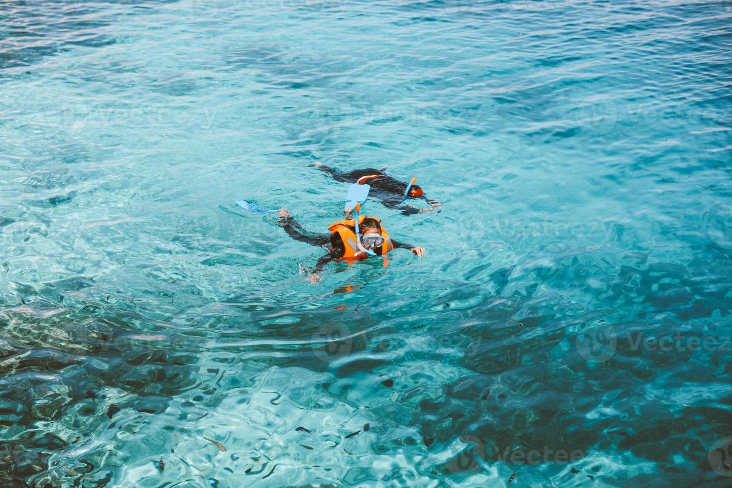 uma mulher turistas está nadando no mar transparente foto