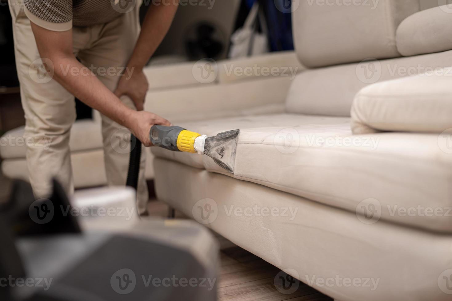 limpando um sofá sujo com uma lavadora de sofá foto