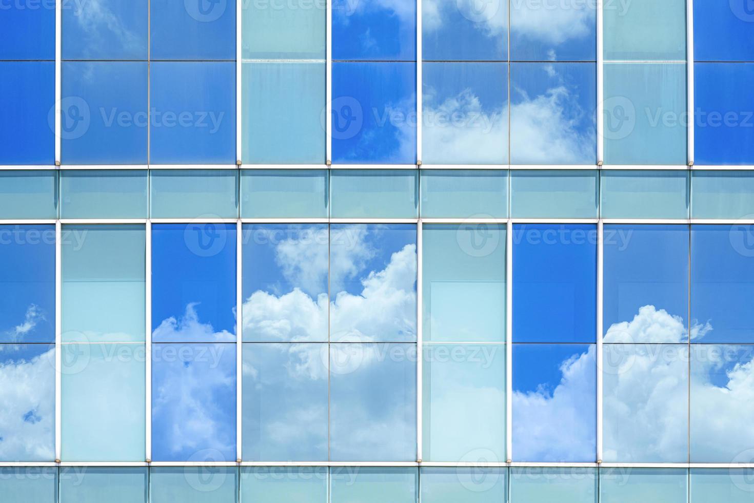 reflexão do céu na superfície da parede do edifício moderno de vidro foto