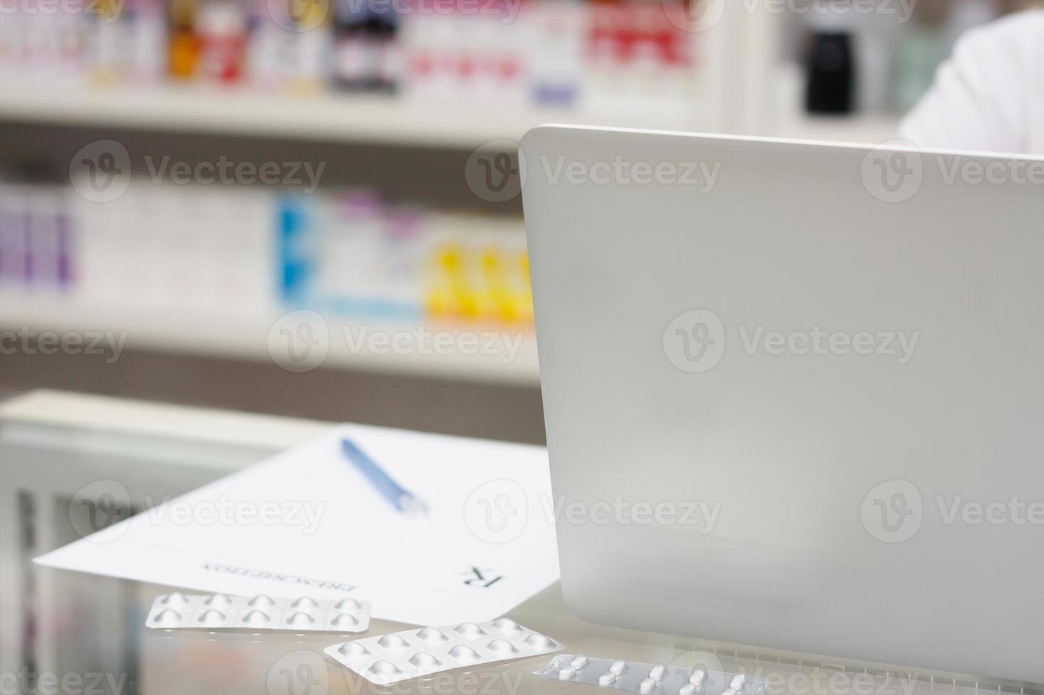 farmacêutico com computador portátil e medicação na farmácia foto