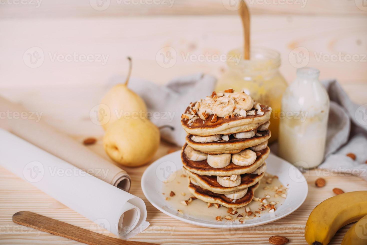 pilha de deliciosas panquecas com mel, nozes e fatias de banana. foto