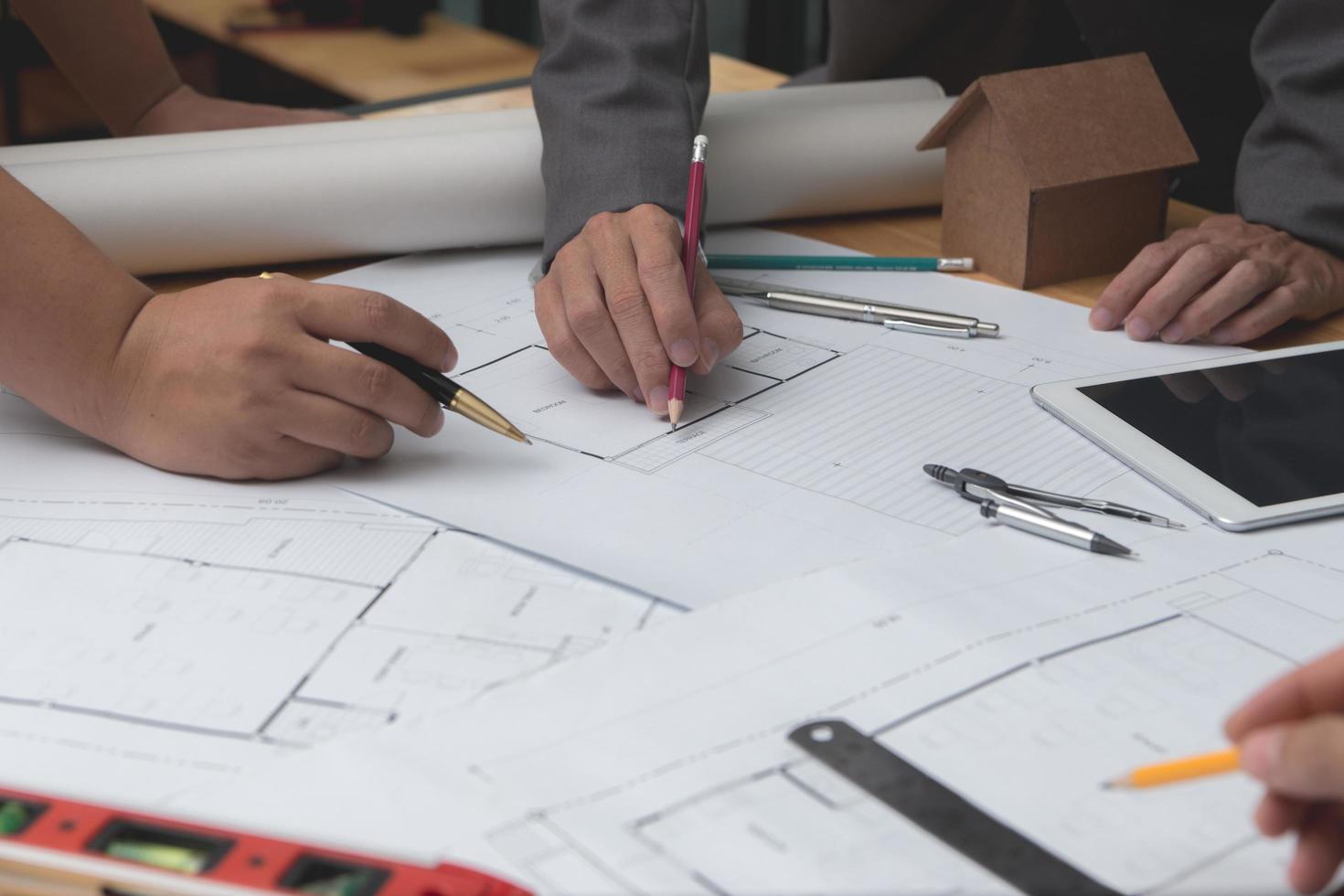 mãos de arquiteto ou engenheiro usando lápis trabalhando com planta na mesa no escritório. ferramentas de engenharia e conceito de construção. foco de arquiteto e negócio concept.selective, efeito vintage. foto