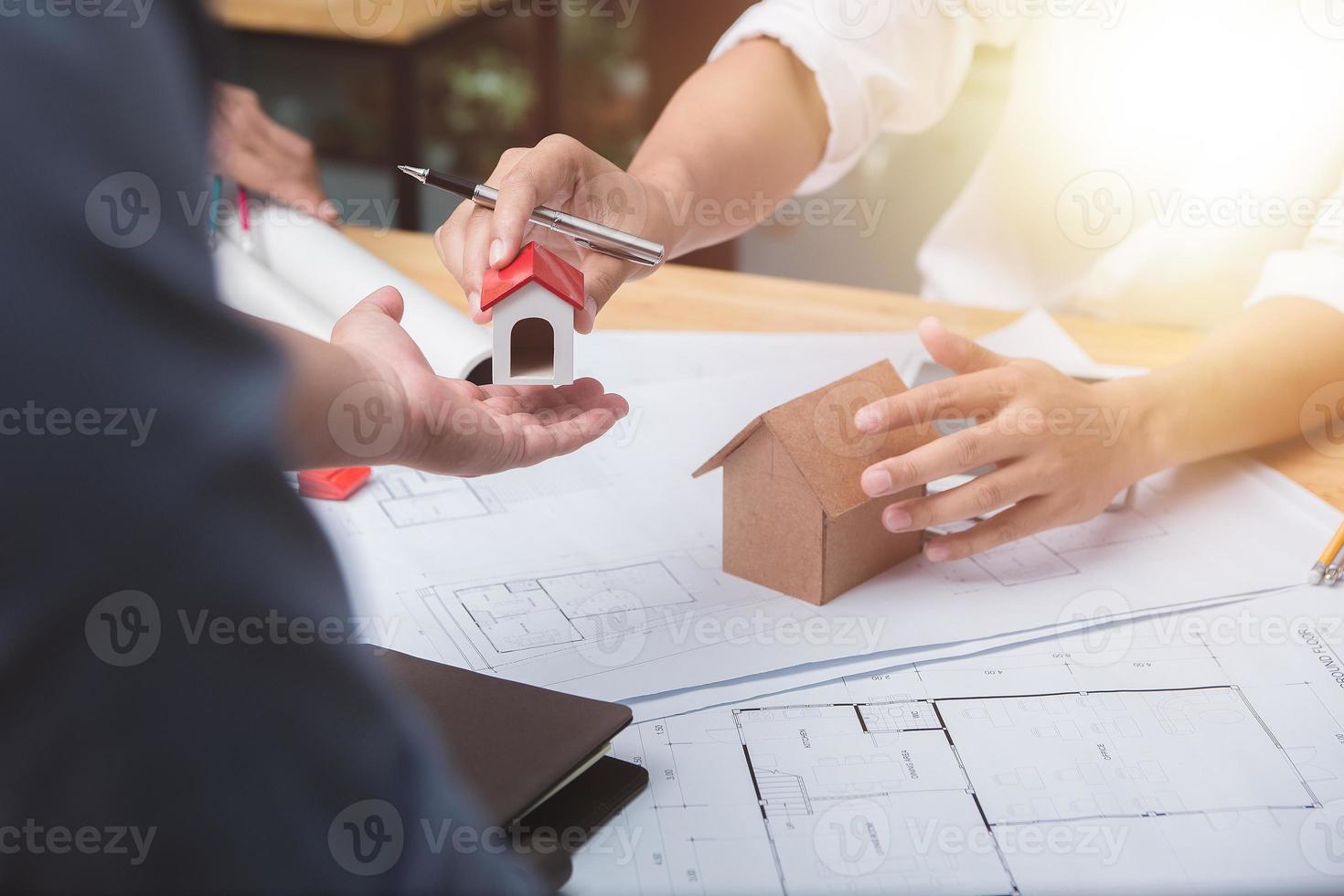 equipe de arquitetos ou engenheiro discutindo na mesa com planta sobre o novo projeto de inicialização na mesa. grupo de equipe em documentos de verificação de site de construção e foco de workflow.selective de negócios. foto