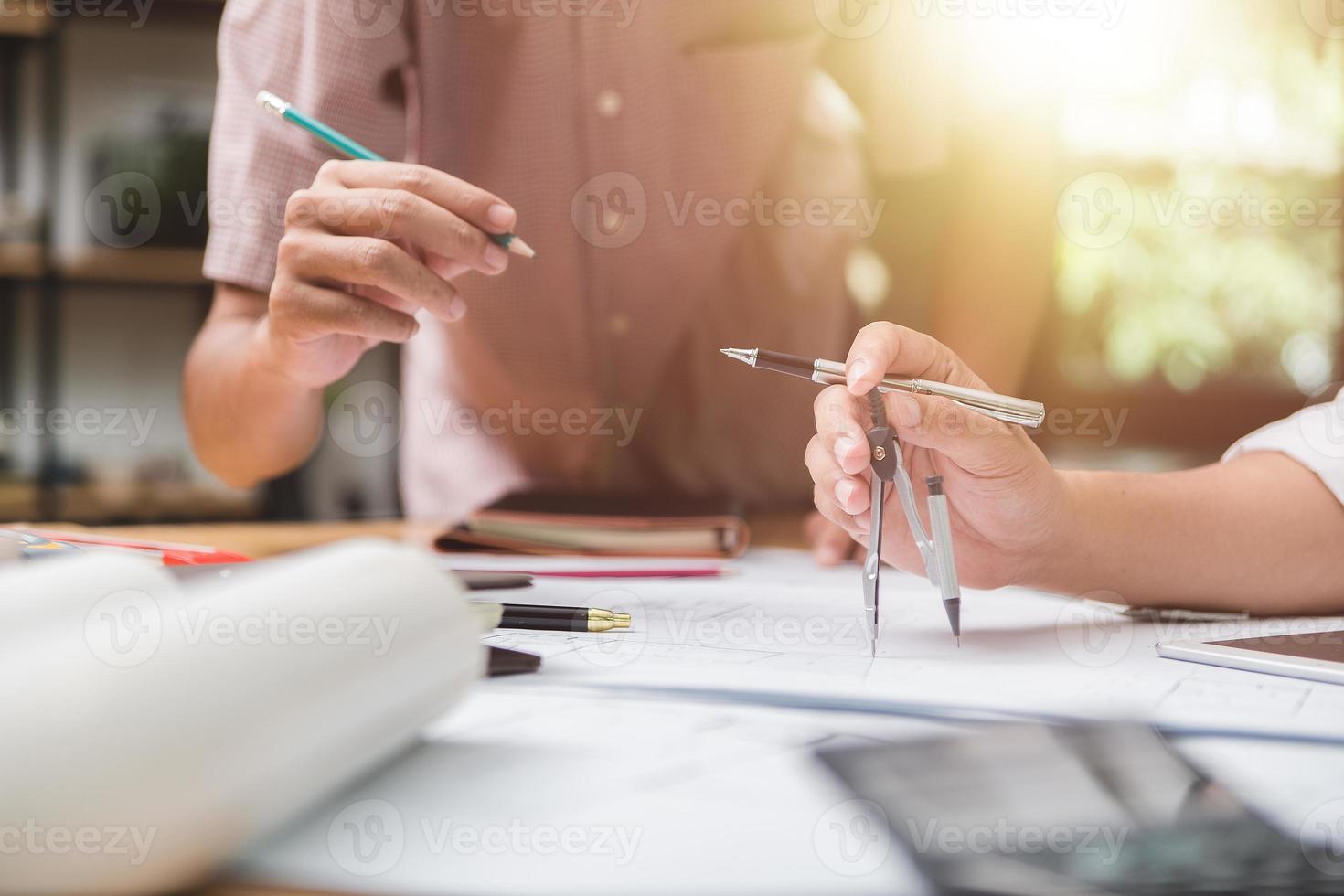 equipe de arquitetos ou engenheiro discutindo na mesa com planta sobre o novo projeto de inicialização na mesa. grupo de equipe em documentos de verificação de site de construção e foco de workflow.selective de negócios. foto