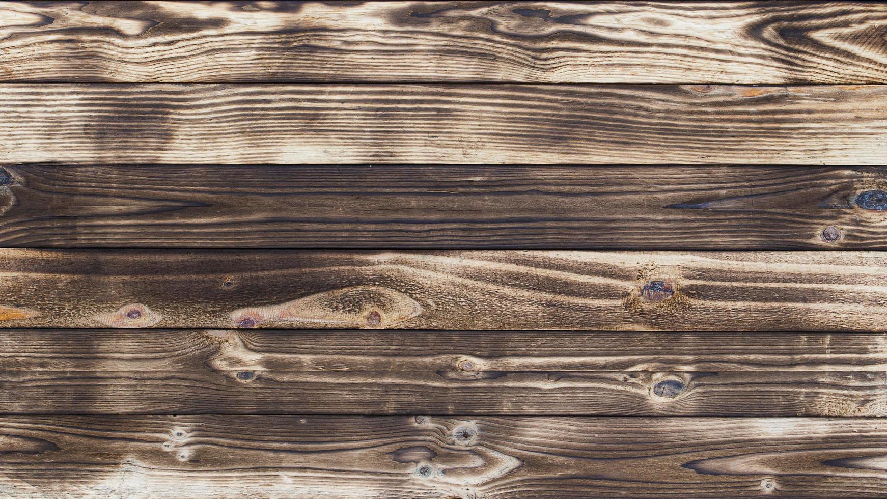 piso de madeira com vestígios de ser queimado faz um fundo abstrato preto e textura. foto