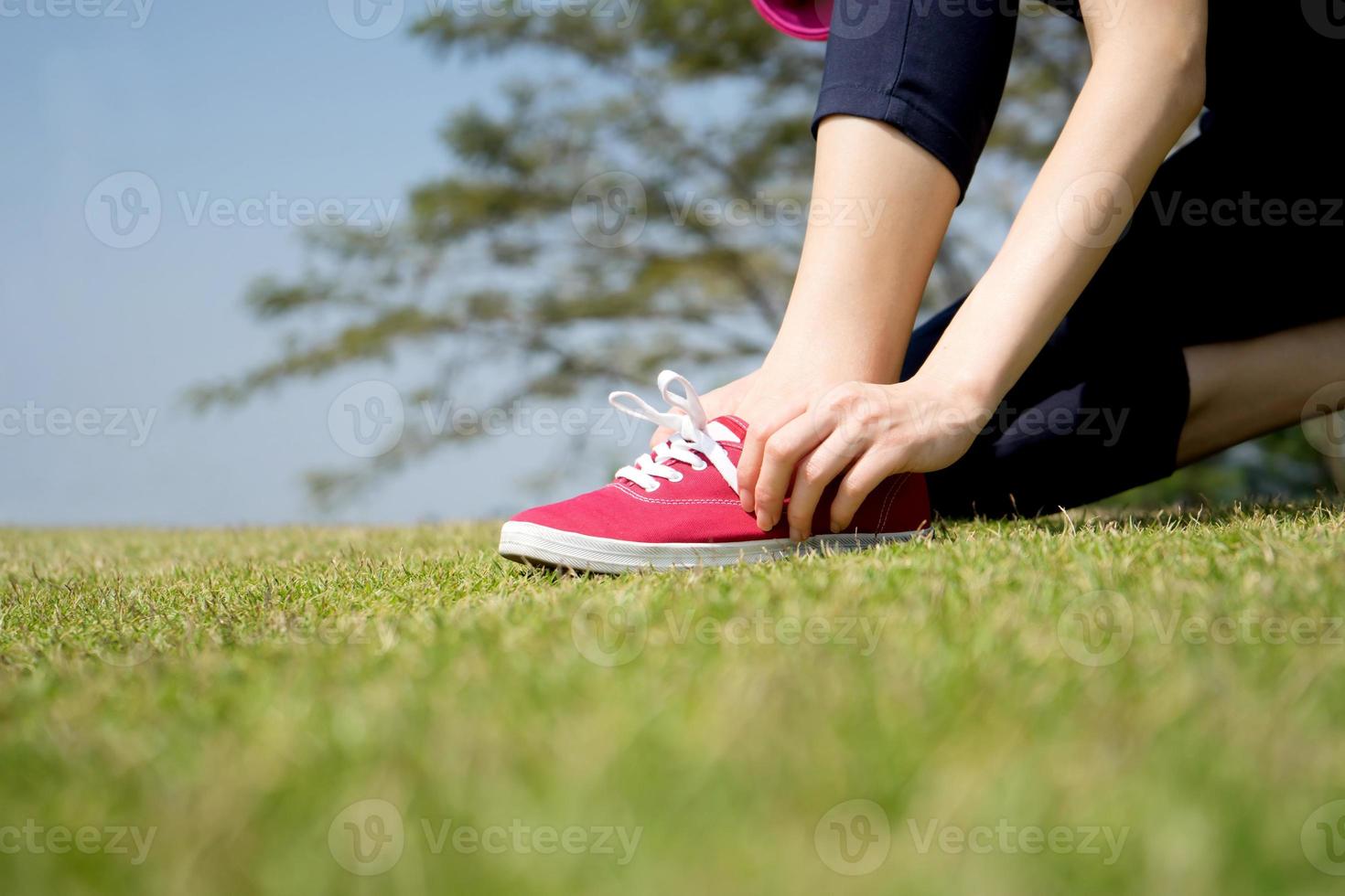 tênis de corrida - closeup de mulher amarrando cadarços em seus tênis descalços. corredor de fitness esporte feminino se preparando para correr ao ar livre. foto