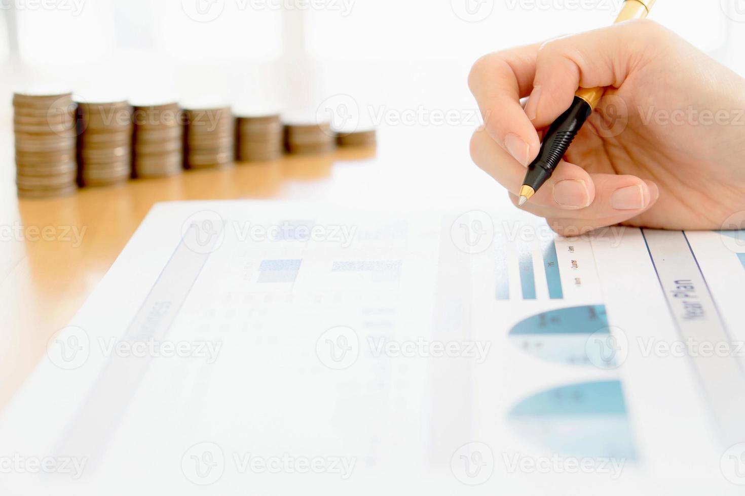 empresária analisando gráfico financeiro com moedas foto