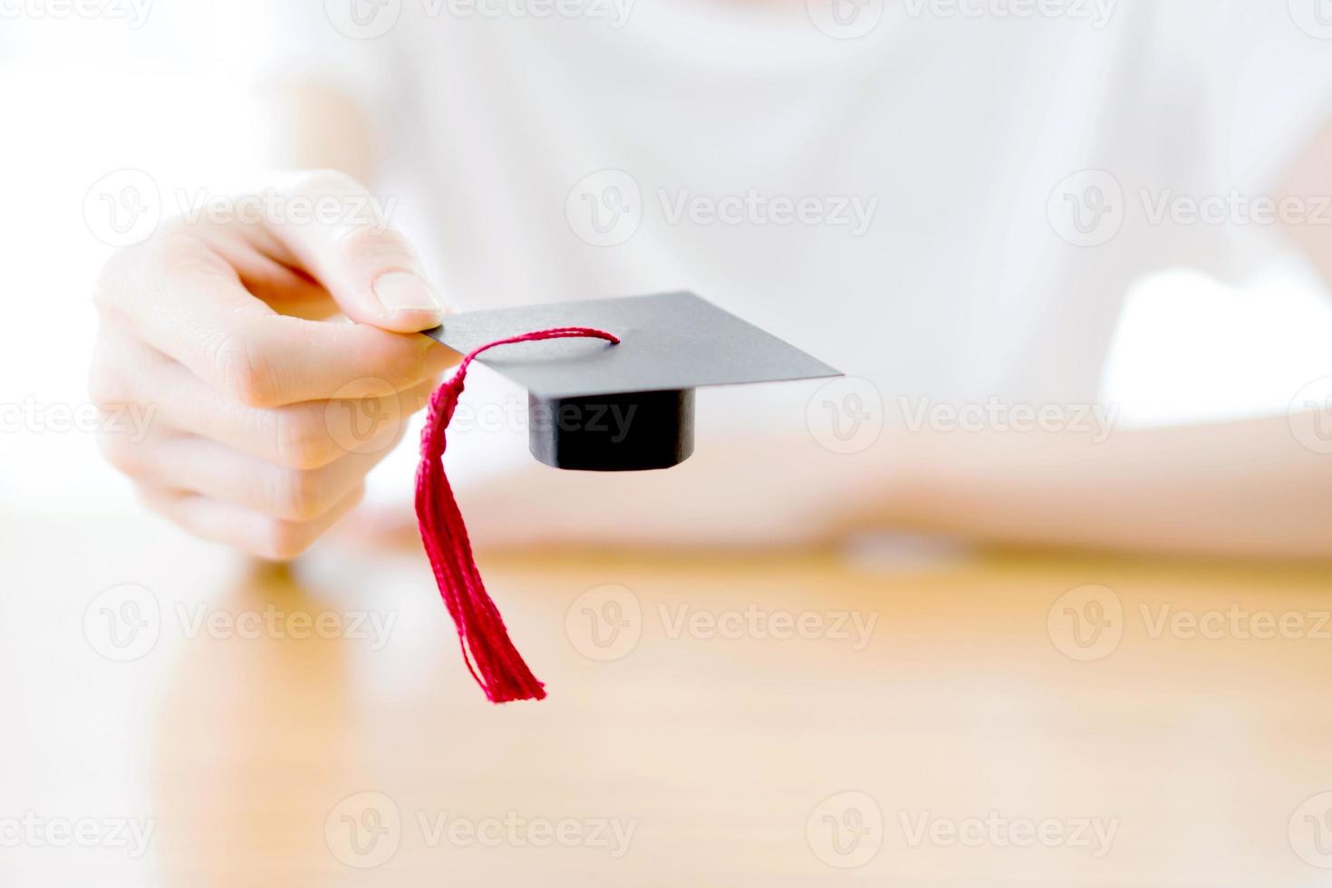 mulher segurando boné de formatura foto