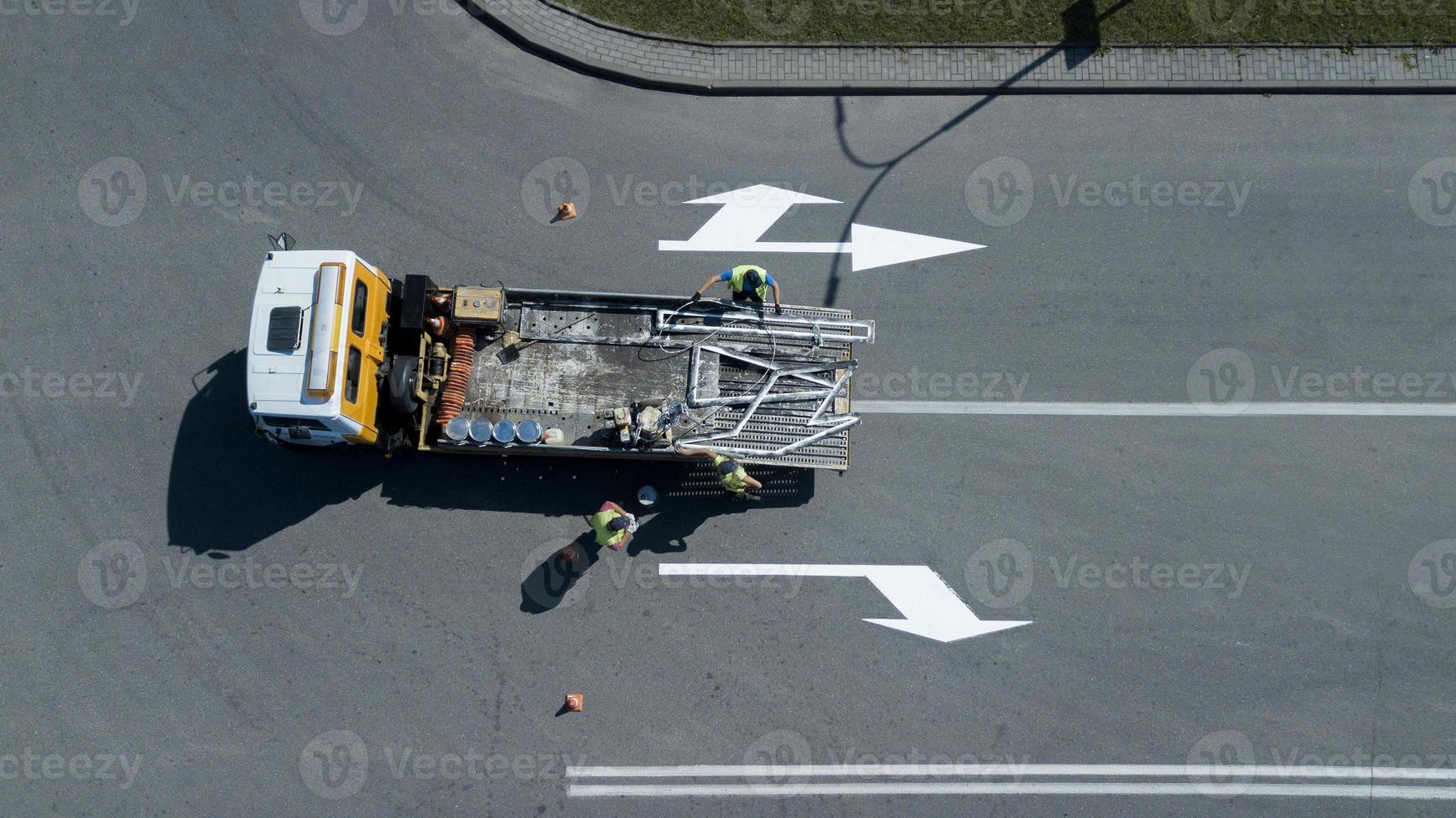 os trabalhadores aplicam a vista superior das marcações rodoviárias foto