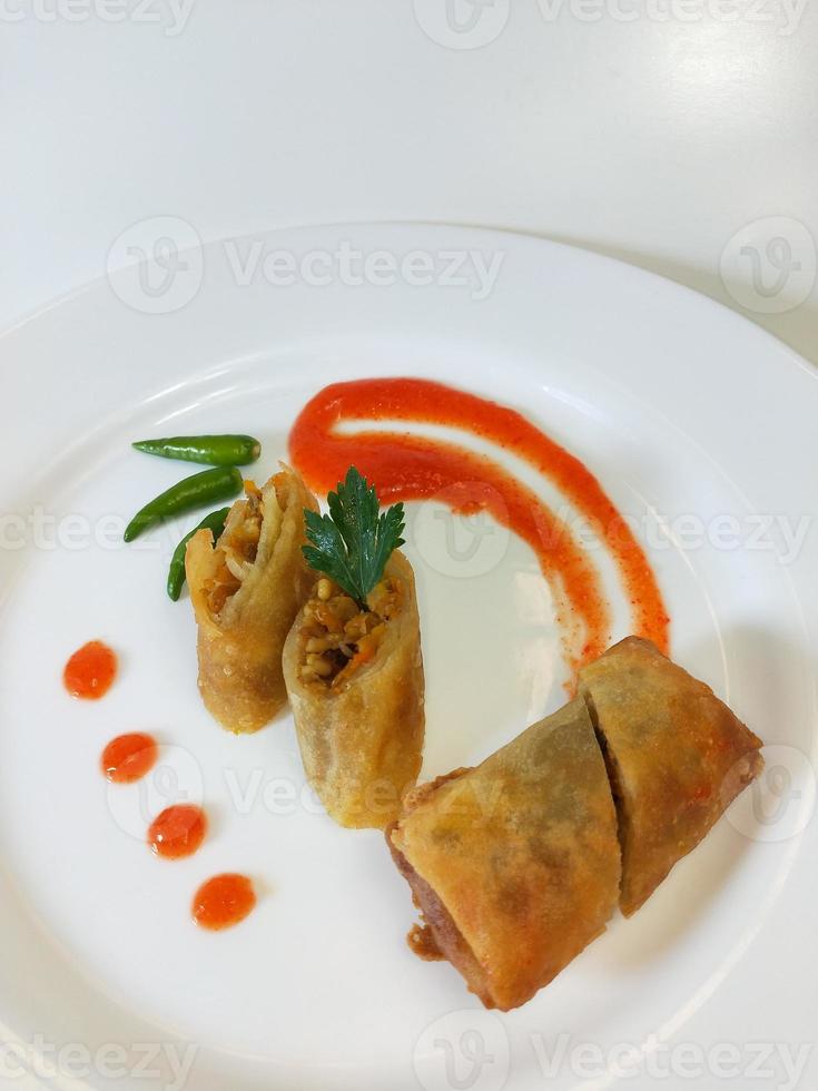 lumpia é um típico lanche indonésio javanês central que consiste em uma mistura de brotos de bambu jovens, ovos, legumes frescos e carne ou frutos do mar, em um rolo feito de folhas finas de farinha de trigo foto