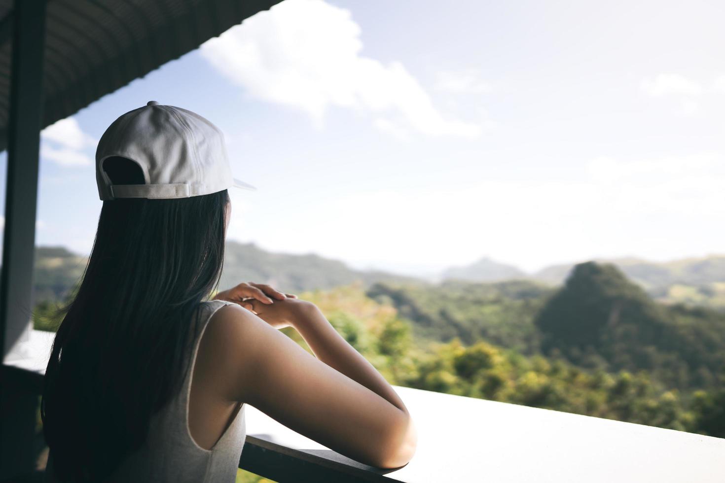 mulher viajante adulta solitária relaxa em casa de família foto