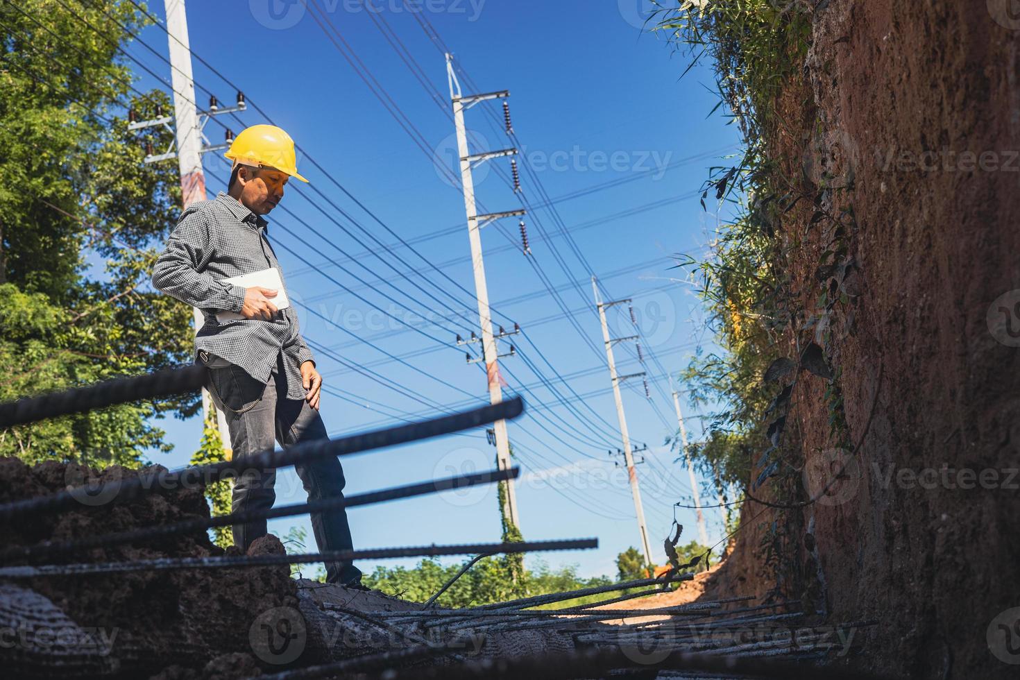 arquiteto ou engenheiro civil com capacete no canteiro de obras, verificando o cronograma no computador tablet foto