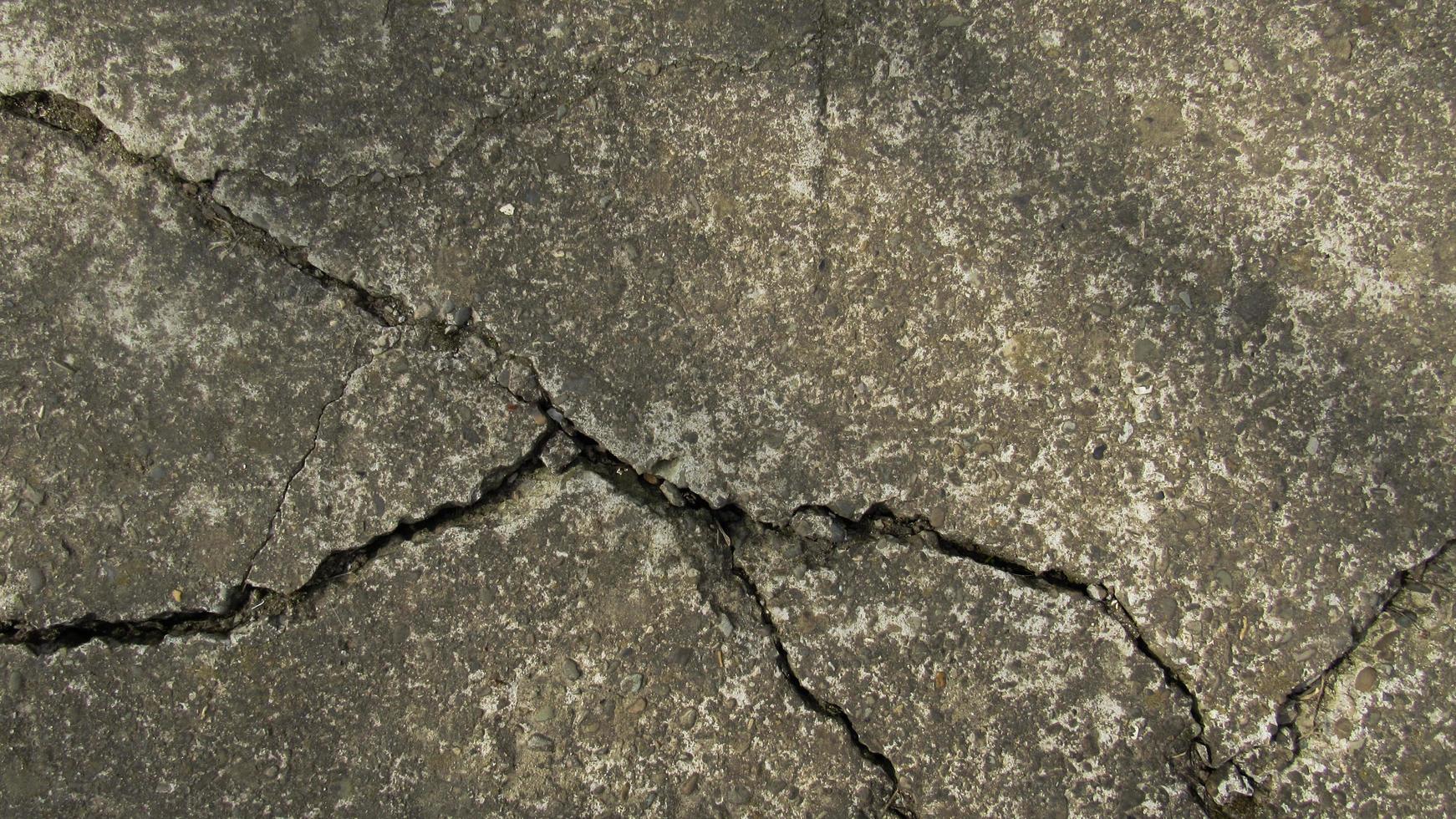 concreto rachado velho. parede de cimento de concreto grunge com crack, para o seu design e textura de fundo. passarela de pedra. textura de concreto foto