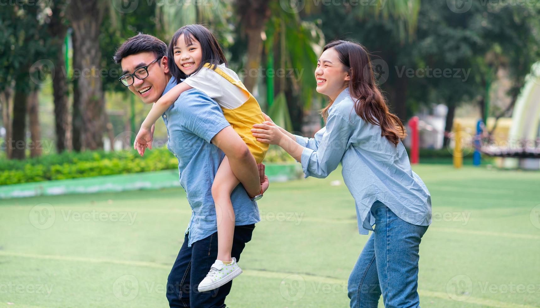 imagem de jovem família asiática brincando juntos no parque foto